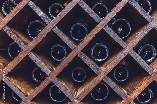 бутылки вина лежат в деревянной винотеке в винном погребе 
