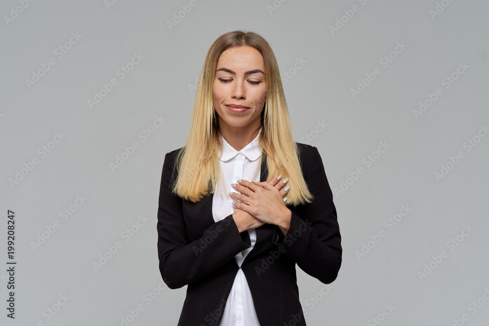 beautiful businesswoman blonde closed her eyes and smiles, folding her hands on her chest. 