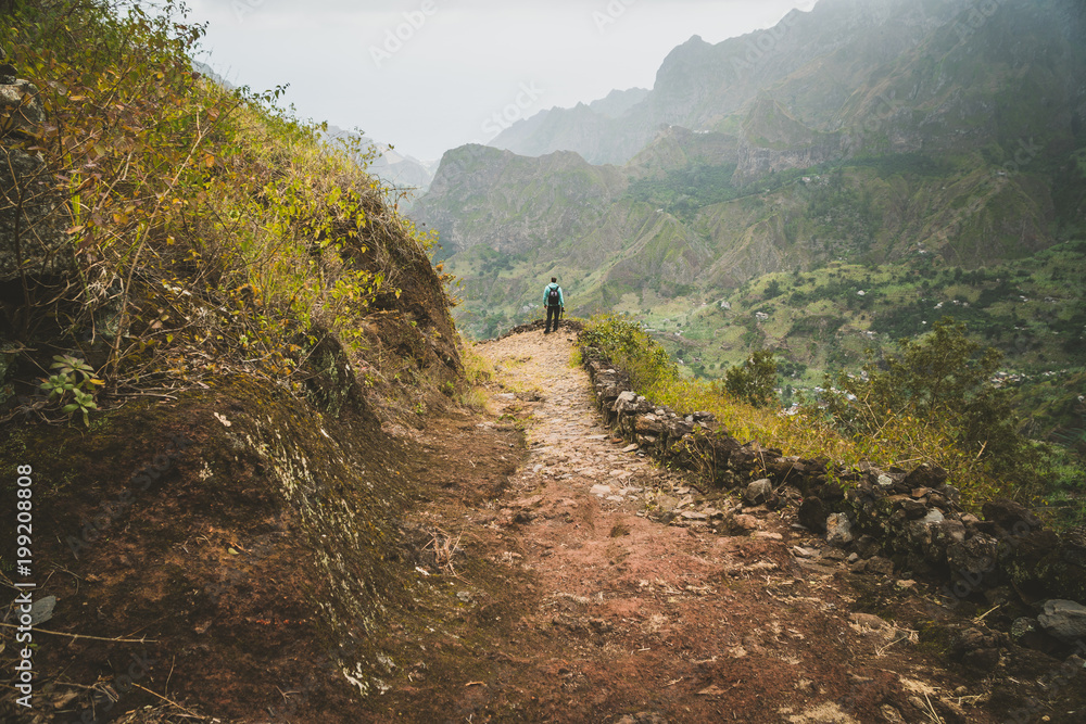 Male hiker enjoying impressive mountainscape. Lash canyon valley extend far below. Santo Antao, Cabo Verde