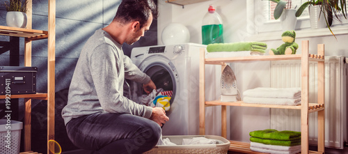 Konstfotografi Man putting clothes into washing machine