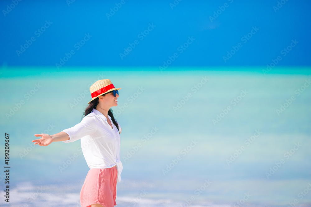 © travnikovstudio - Young woman enjoying the sun sunbathing by perfect turquoise ocean.