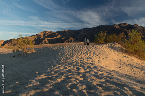 Couple watching the sun set at Mesquite Flat Dunes  Sand dunes at Death Valley National Park