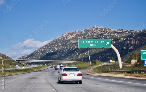 Scenic car road trip travels from California to Arizona (United States of America): Empty highway with minimal traffic on a sunny day with a clear blue sky with shite clouds
