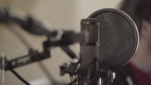 Young man creating music with music production microphone. Young man is mixing audio and recording music.