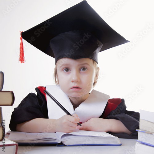 Child girl college graduate thinking about her perspectiv and future job. Humorous photo. (Knowledge, studies, work, career concept)