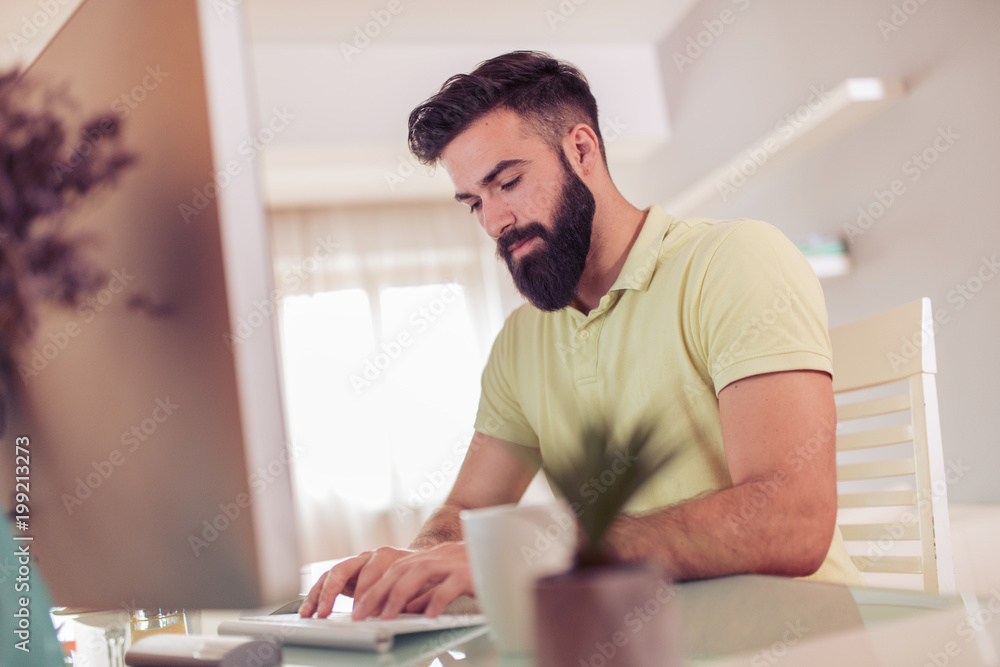 Man working from home on computer Man working from home on computer