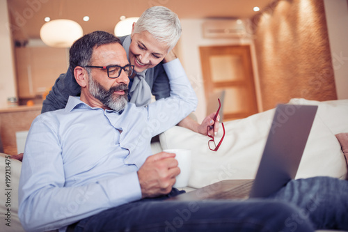 Mature couple using laptop computer at home