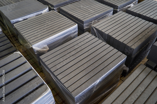 Paving slabs factory. Tiles piled in pallets. Warehouse paving slabs in the factory for its production © Gecko Studio