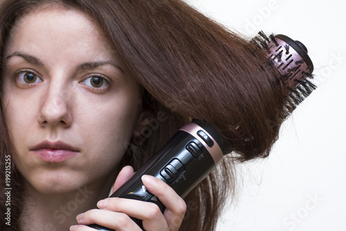 Redhead model using an air styler brush to dry and style her hair
