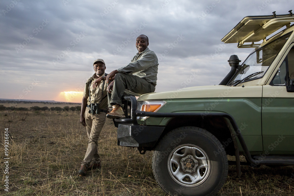 Portrait of friends by off road vehicle at Serengeti National Park Portrait of friends by off road vehicle at Serengeti National Park