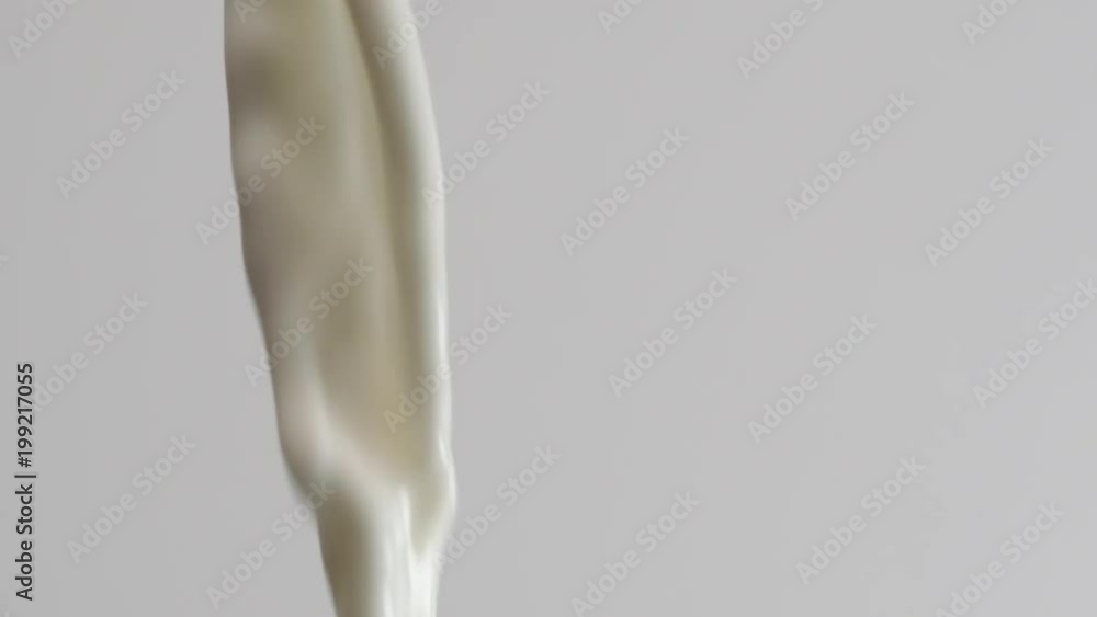 Slow motion cream poured out. Macro shot of milk pouring out in super slow motion Slow motion cream poured out. Macro shot of milk pouring out in super slow motion