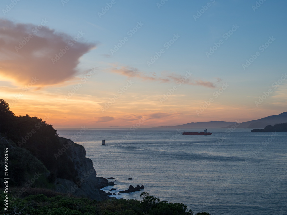 Cargo ship sailing in Bay Area with setitng sun