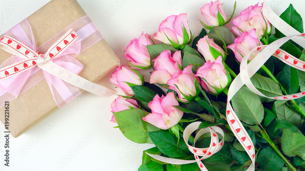 Happy Mother's Day overhead with gift and pink roses on white wood table background Happy Mother's Day overhead with gift and pink roses on white wood table background