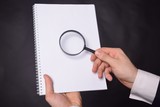Businessman looking at a magnifying glass word: