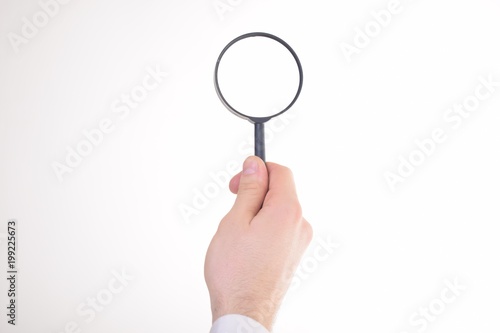 Businessman looking at a magnifying glass word: