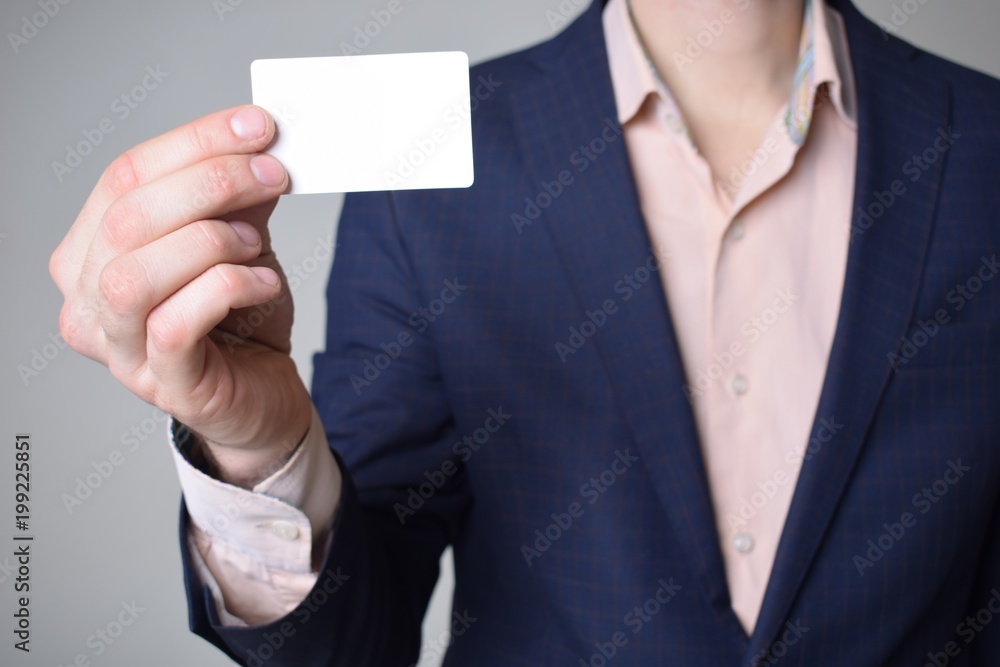 Fototapeta premium Businessman shows business card with the inscription: