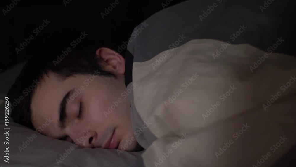 Young man in his bed geting set for the night. Young man in his bed geting set for the night.