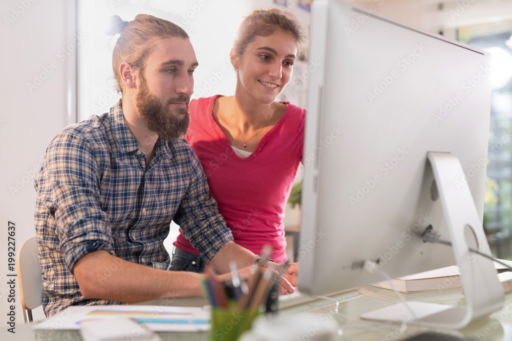 office, two young colleagues, a man and a woman, discuss a project office, two young colleagues, a man and a woman, discuss a project