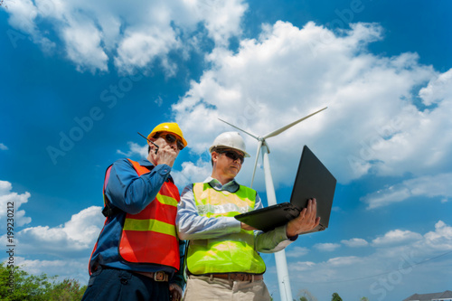 Male Engineer or technician use laptop computer  on work site wind turbine generator  station ,wind enegy ,wind power concept