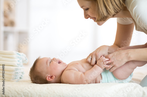 Fotografie Mom changing a diaper on newborn baby