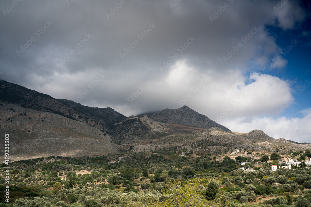 Fototapeta premium Field and mountain against cloudy sky