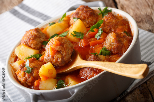 Delicious homemade soup with meatballs close-up in a pot. horizontal
