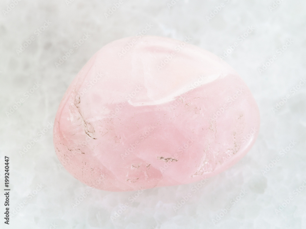 tumbled Rose Quartz gem stone on white marble tumbled Rose Quartz gem stone on white marble