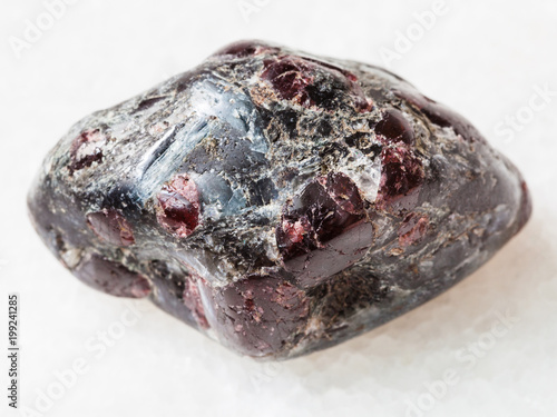 tumbled Almandine garnet crystals on white marble photo