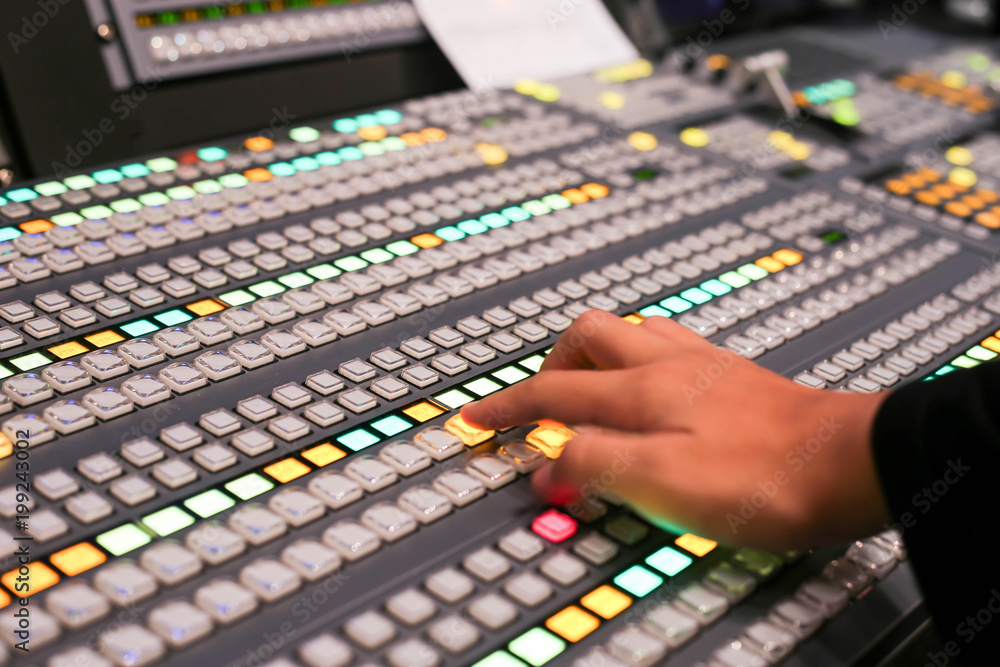 Hands push a button of Switcher buttons in studio TV station, Audio and Video Production Switcher of Television Broadcast. Hands push a button of Switcher buttons in studio TV station, Audio and Video Production Switcher of Television Broadcast.