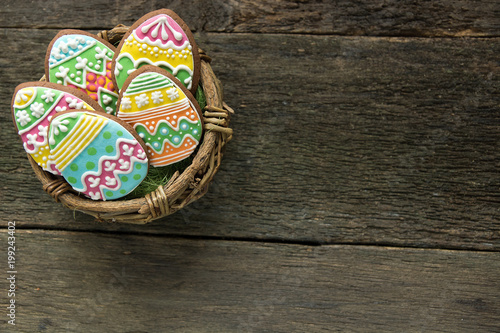 gingerbread cookie in the form of color eggs on dark wooden background.