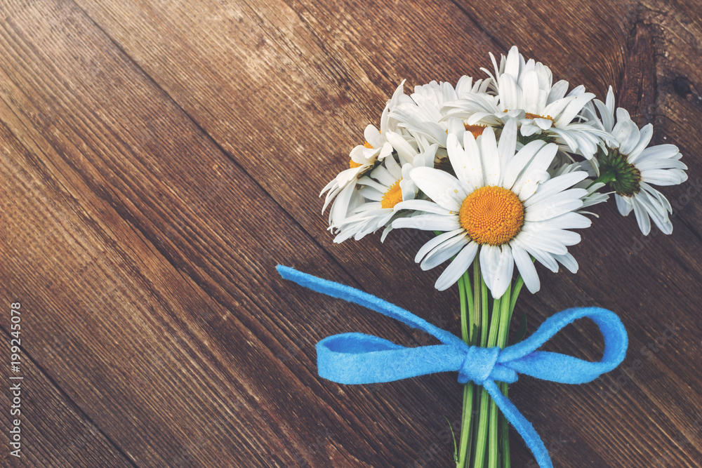 Fototapeta premium Bouquet of chamomile on the wooden table