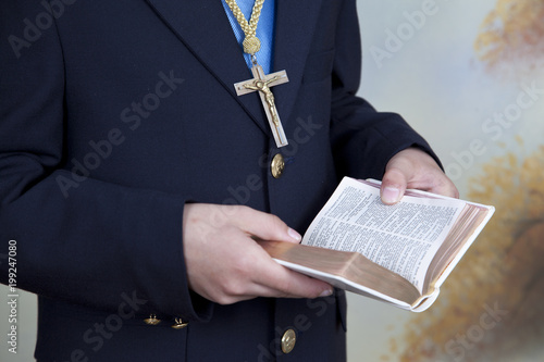 detail of the hands of a boy dressed in a blue communion suit