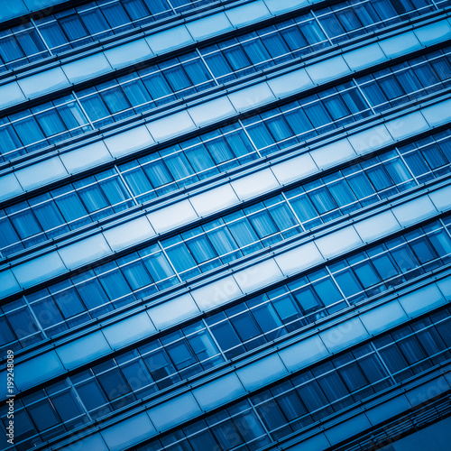 full frame of modern glass building blue toned.
