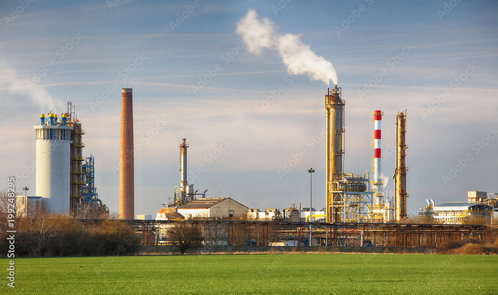 Smoking chimneys of a petrochemical factory in an oil refinery Smoking chimneys of a petrochemical factory in an oil refinery