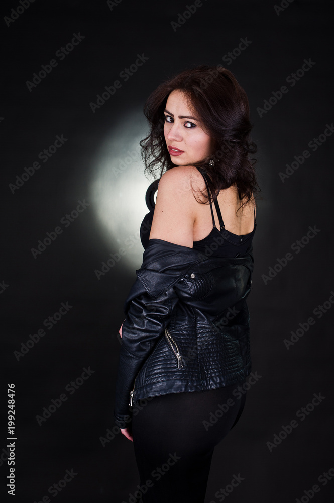 Studio portrait of sexy brunette girl in black leather jacket against black background. Studio portrait of sexy brunette girl in black leather jacket against black background.