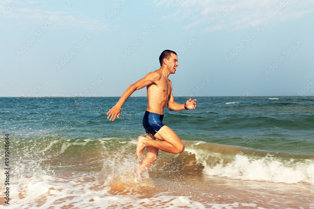 Man running in water on the beach