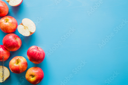 Beautiful, fresh, colorful apples on the blue background. Healthy sweet food concept. Mock up for fruits offers as advertising or web background, or other ideas. Empty place for text or logo.