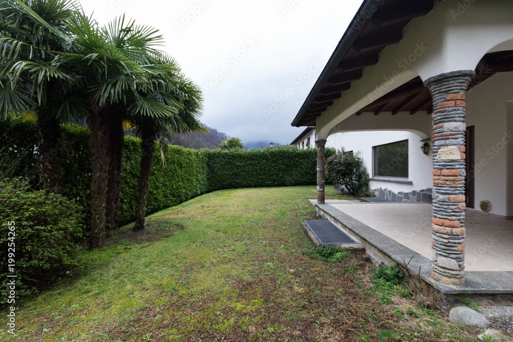 Exterior of villa with large garden on a winter day Exterior of villa with large garden on a winter day