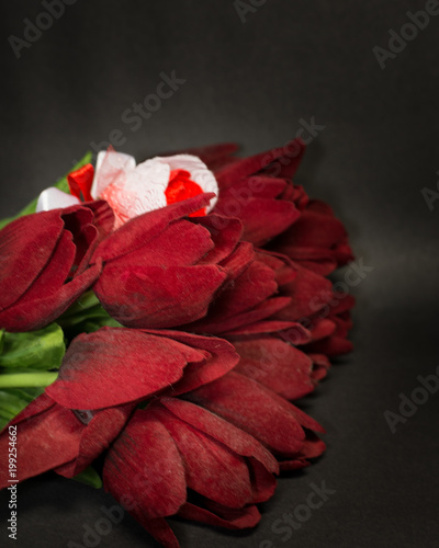 fake red tulips on the black background