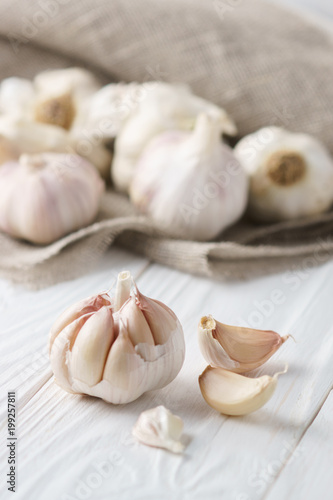 Garlic bulb with garlic cloves on white rustic wood.