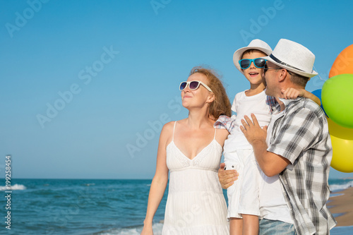 Father mother and son playing on the beach at the day time.