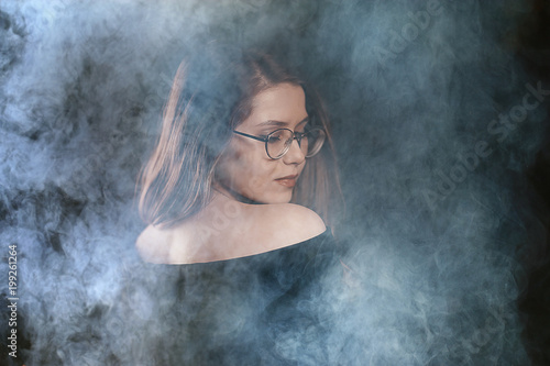 portrait of a woman in a smoke, eyes in glasses / business concept, beautiful woman, sexy business girl. Stress, smoking, relaxed.