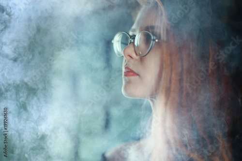 portrait of a woman in a smoke, eyes in glasses / business concept, beautiful woman, sexy business girl. Stress, smoking, relaxed. © kichigin19