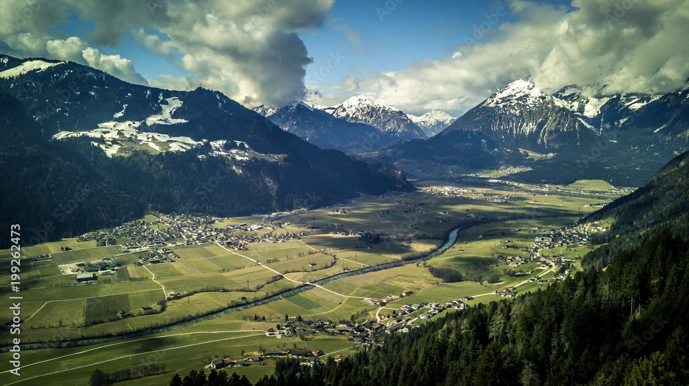 Aerial view on beautiful, mountains landscape and the city Innsbruck is among them. Sunny, spring day. View from drone.