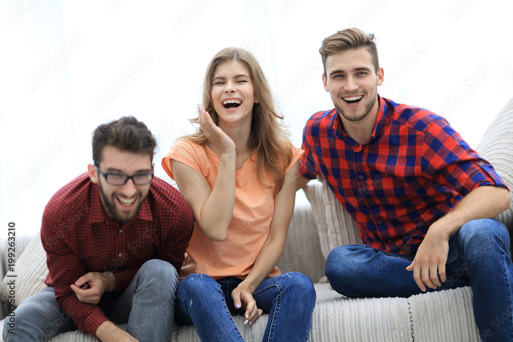 group of young people laughing and sitting on the couch group of young people laughing and sitting on the couch