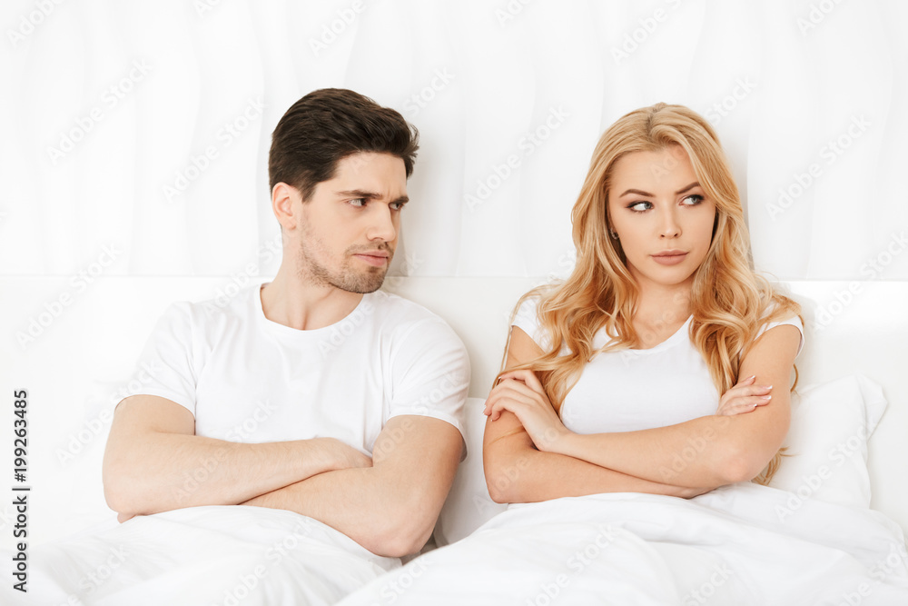 Angry loving couple lies in bed indoors at home quarrel. Angry loving couple lies in bed indoors at home quarrel.