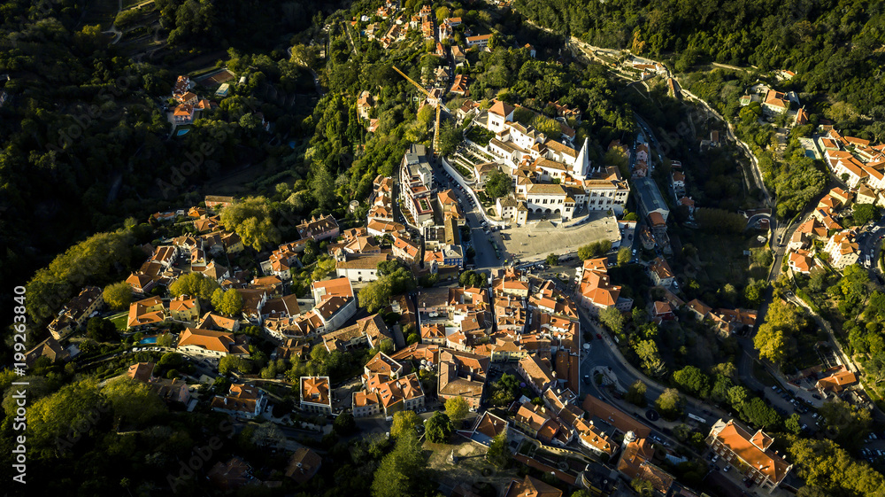 Aerial view from drone on small town located in mountains near by Lisbon - Sintra. Red rooftops, streets, town infrastructure is seen on image. Portugal. Top view. Aerial view from drone on small town located in mountains near by Lisbon - Sintra. Red rooftops, streets, town infrastructure is seen on image. Portugal. Top view.