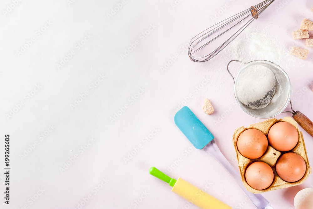 Ingredients and utensils for cooking baking egg, flour, sugar, whisk, rolling pin, on light pink background, top view copy space Ingredients and utensils for cooking baking egg, flour, sugar, whisk, rolling pin, on light pink background, top view copy space