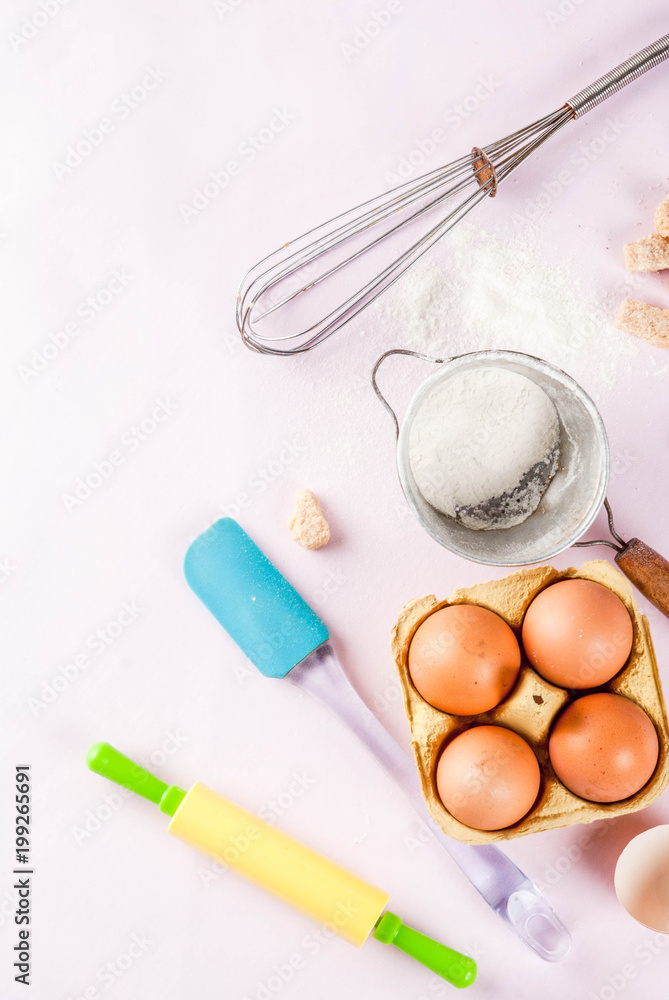 Ingredients and utensils for cooking baking egg, flour, sugar, whisk, rolling pin, on light pink background, top view copy space Ingredients and utensils for cooking baking egg, flour, sugar, whisk, rolling pin, on light pink background, top view copy space