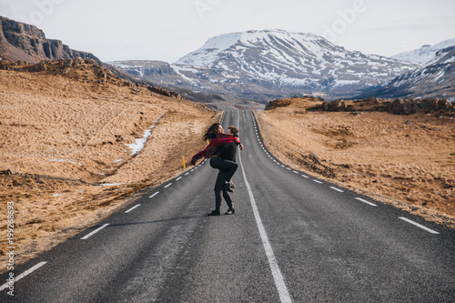 happy young couple hugging on road in iceland, hvalfjardarvegur
